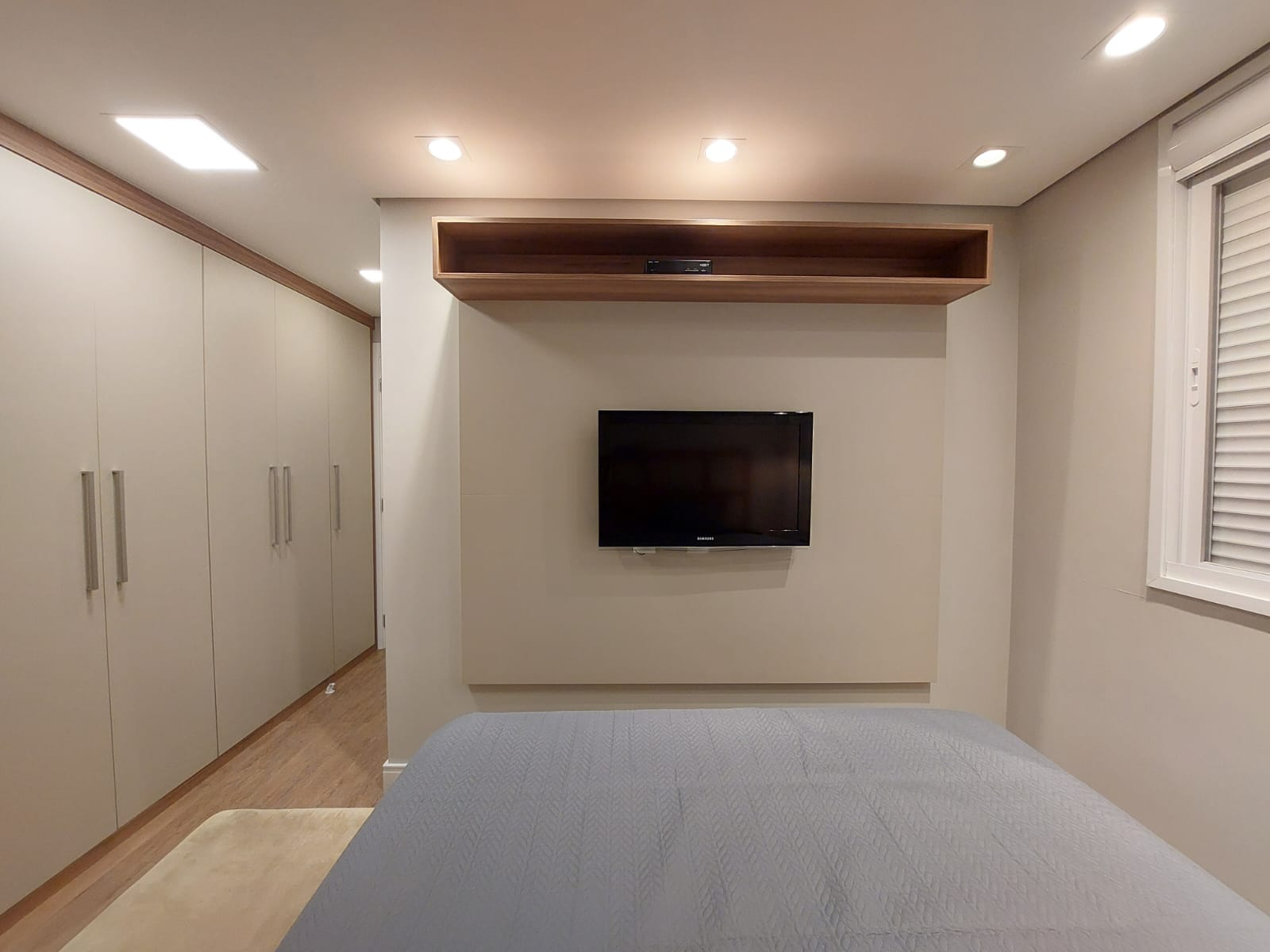 Suíte com painel de TV e guarda-roupa integrado